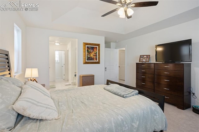 bedroom featuring ceiling fan, light colored carpet, and a raised ceiling