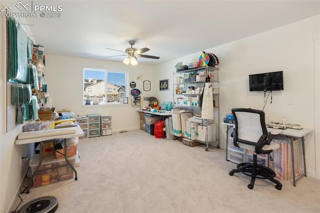 carpeted office space featuring ceiling fan