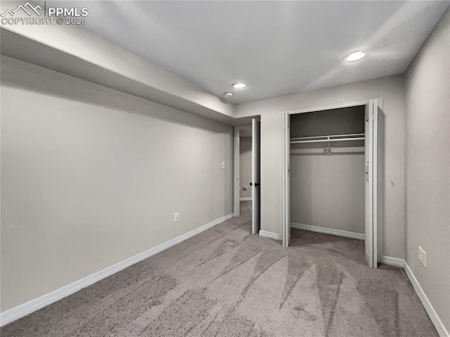 unfurnished bedroom featuring light colored carpet and a closet