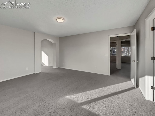 carpeted empty room with a textured ceiling