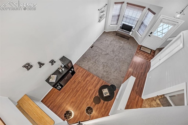 carpeted living room featuring a high ceiling and wooden walls