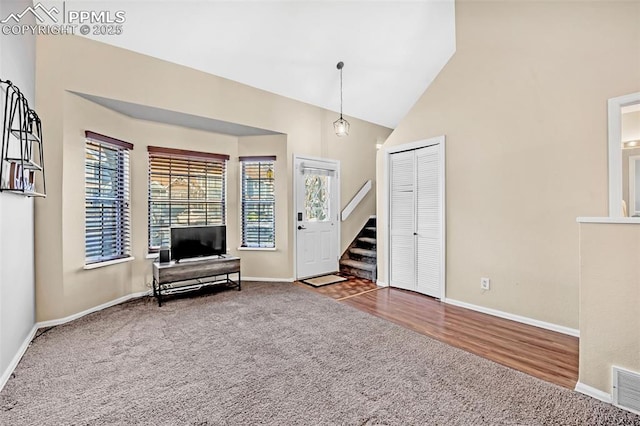 unfurnished room featuring carpet floors and high vaulted ceiling