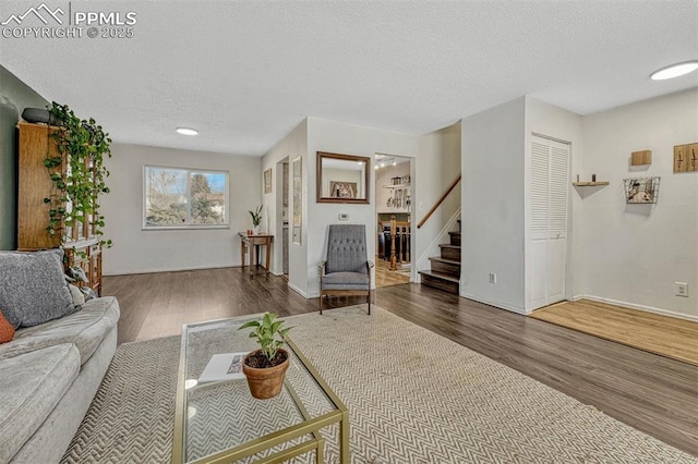 living room with dark wood-type flooring and a textured ceiling