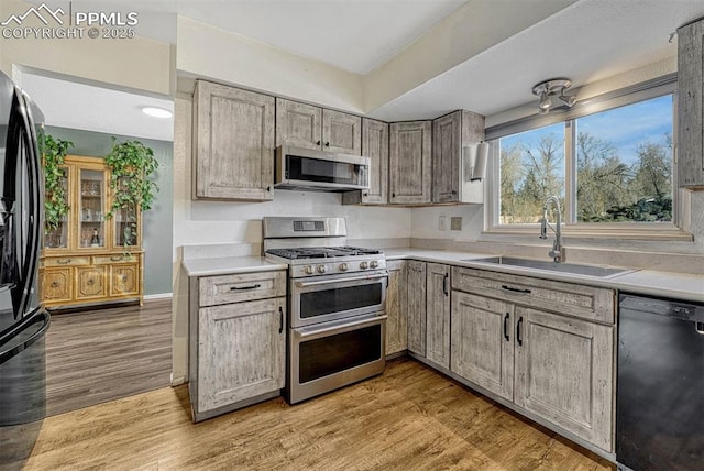 kitchen featuring sink, light hardwood / wood-style flooring, and black appliances