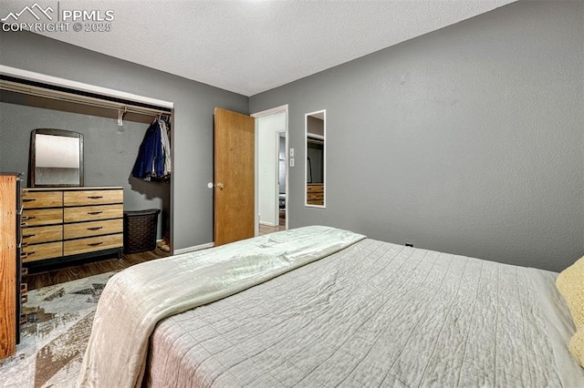 bedroom with dark hardwood / wood-style floors, a textured ceiling, and a closet