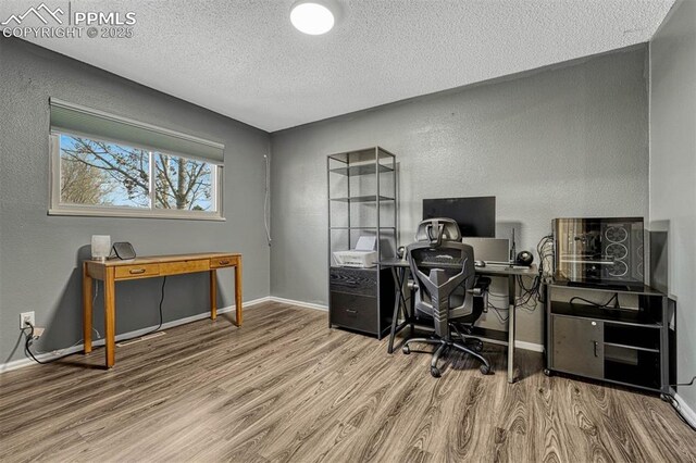 home office with hardwood / wood-style floors and a textured ceiling