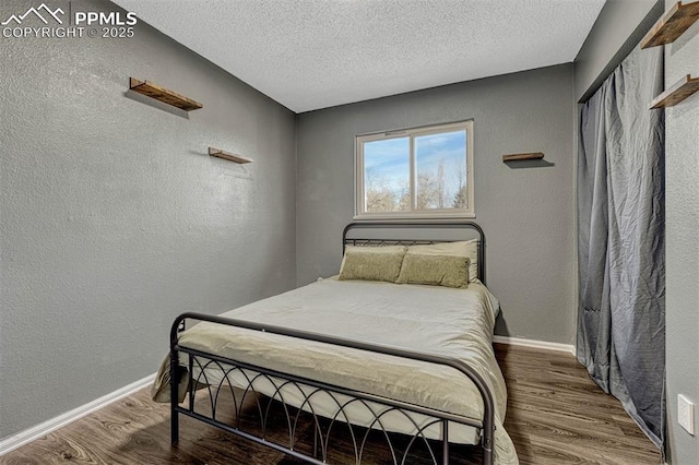 bedroom featuring hardwood / wood-style flooring and a textured ceiling