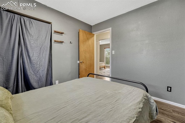 bedroom with hardwood / wood-style flooring and a textured ceiling