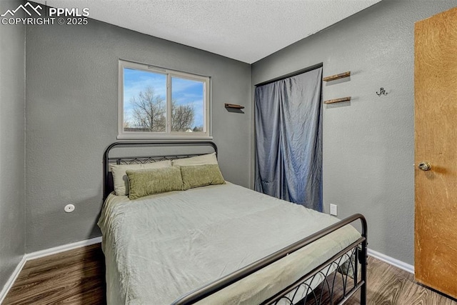 bedroom with dark wood-type flooring and a textured ceiling