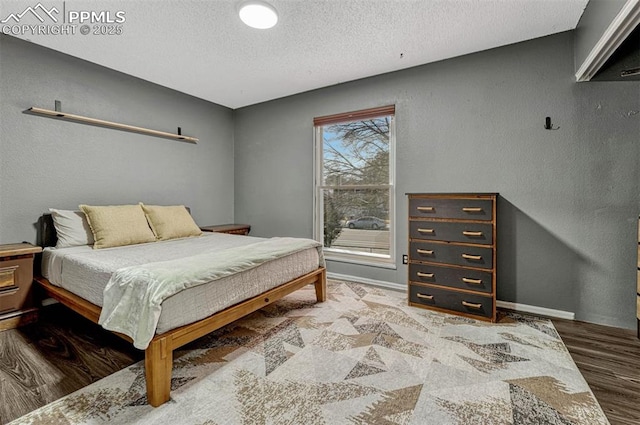 bedroom featuring wood-type flooring and a textured ceiling