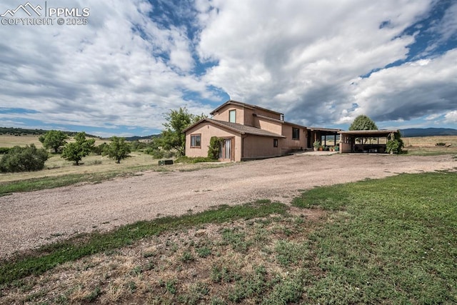 view of front of home with a mountain view, a rural view, and a carport