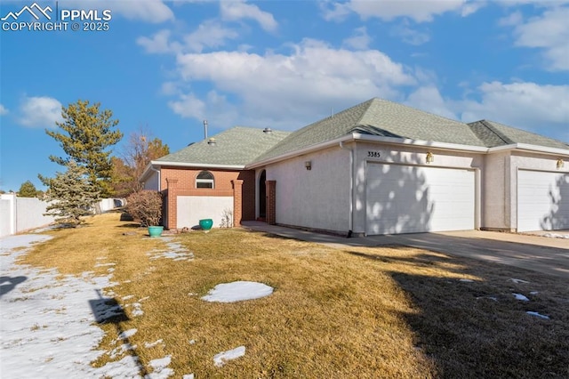 rear view of property with a garage and a yard