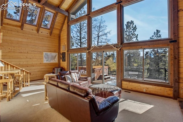 living room featuring wooden ceiling, wood walls, a skylight, high vaulted ceiling, and carpet flooring