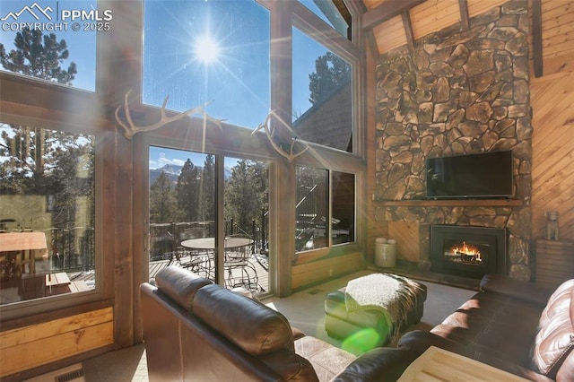 sunroom featuring vaulted ceiling and a fireplace