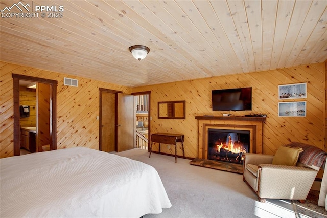 carpeted bedroom featuring wood ceiling and wooden walls