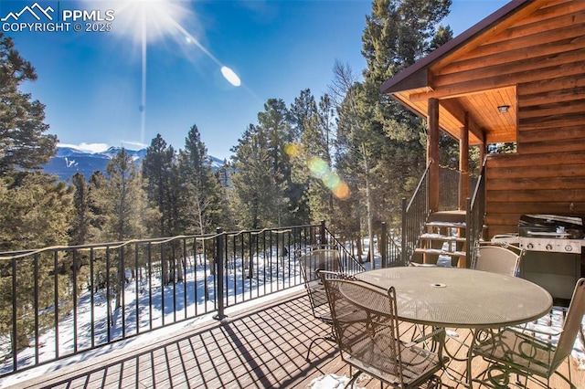 snow covered patio featuring grilling area and a mountain view