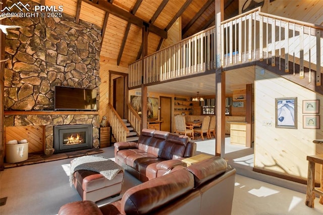 living room with wooden walls, high vaulted ceiling, beam ceiling, a fireplace, and wooden ceiling