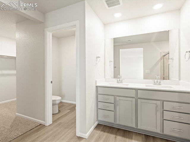 bathroom with vanity, hardwood / wood-style flooring, and toilet