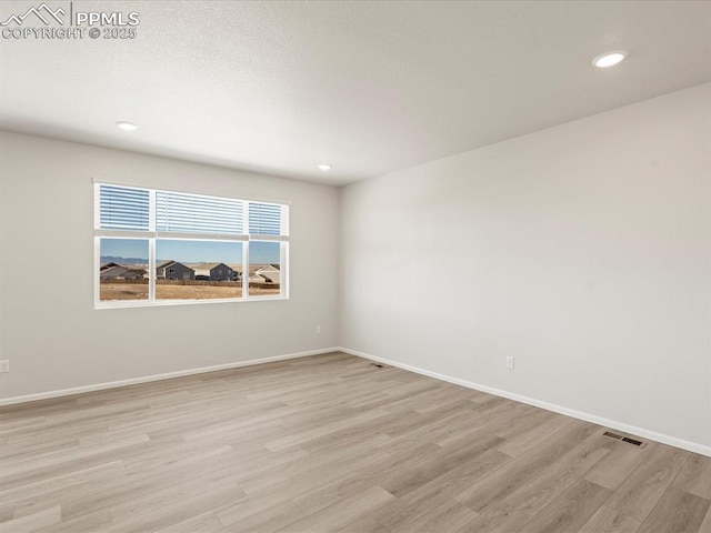 spare room with light hardwood / wood-style flooring