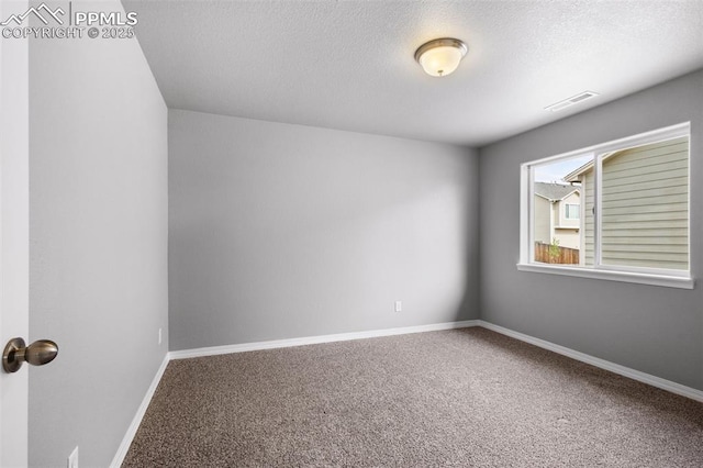 empty room featuring carpet flooring and a textured ceiling