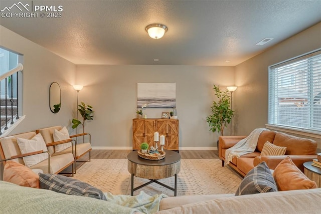 living room featuring light hardwood / wood-style flooring and a textured ceiling