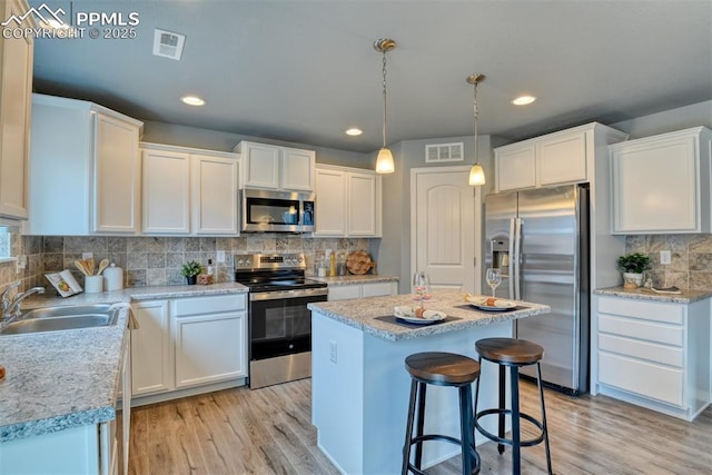 kitchen with stainless steel appliances, sink, and white cabinets