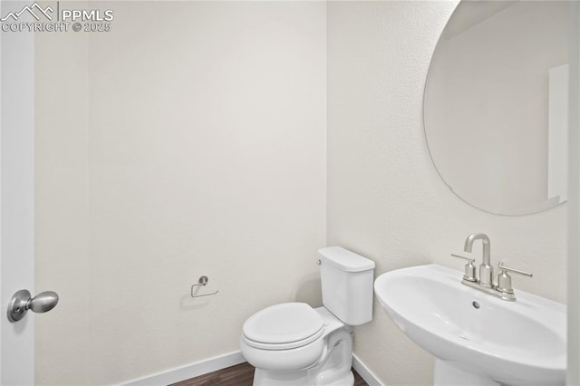 bathroom with hardwood / wood-style flooring, sink, and toilet