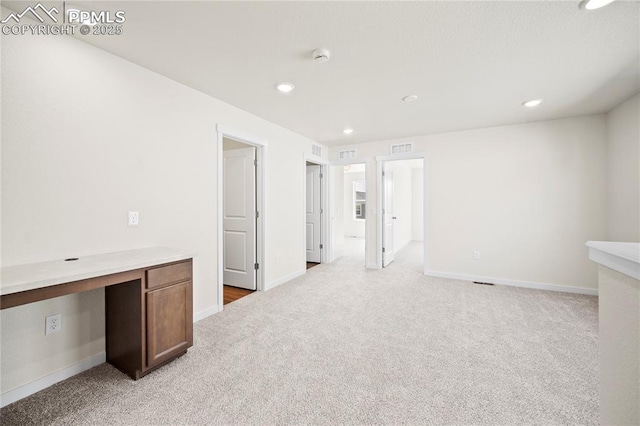 carpeted empty room with built in desk