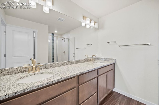 bathroom with vanity, a shower with shower door, and hardwood / wood-style flooring