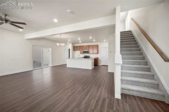 unfurnished living room with ceiling fan with notable chandelier, dark hardwood / wood-style flooring, and sink