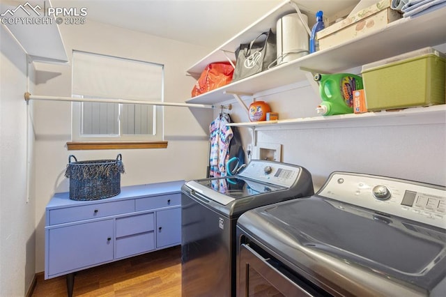 clothes washing area featuring hardwood / wood-style flooring and independent washer and dryer