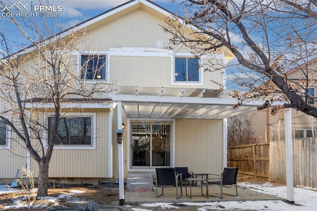 snow covered house featuring a pergola and a patio