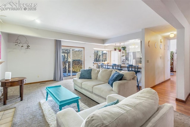 living room with light hardwood / wood-style flooring and a notable chandelier