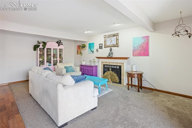 living room with a tile fireplace and beam ceiling