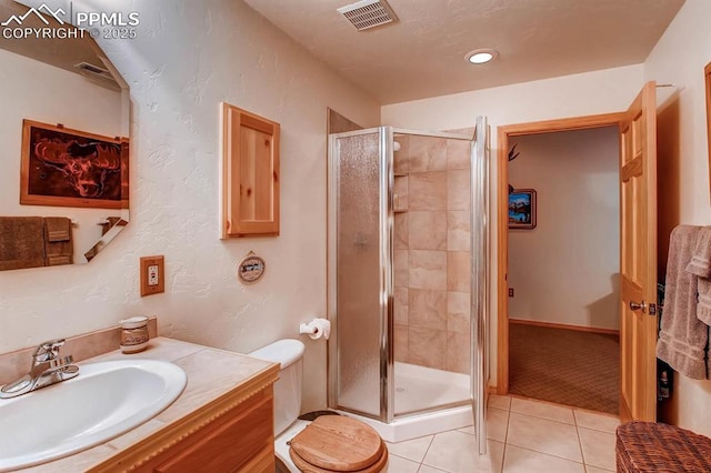 bathroom featuring vanity, toilet, a shower with shower door, and tile patterned flooring