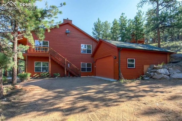 rear view of property featuring a garage