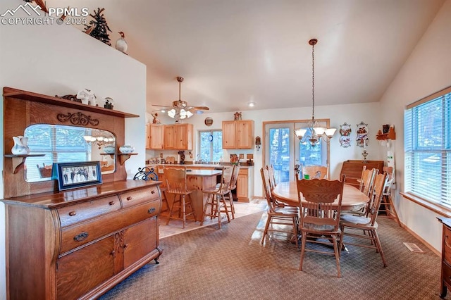 dining room featuring lofted ceiling, ceiling fan with notable chandelier, and light carpet