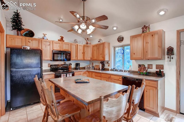 kitchen featuring light brown cabinetry, a breakfast bar area, black appliances, and a kitchen island