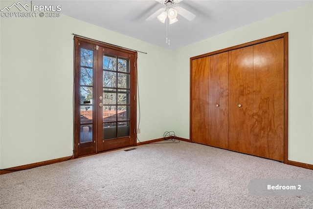 unfurnished bedroom featuring ceiling fan, a closet, french doors, and carpet flooring