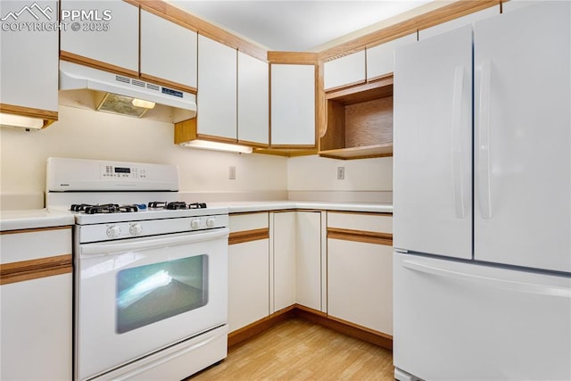 kitchen with white appliances, white cabinets, and light wood-type flooring