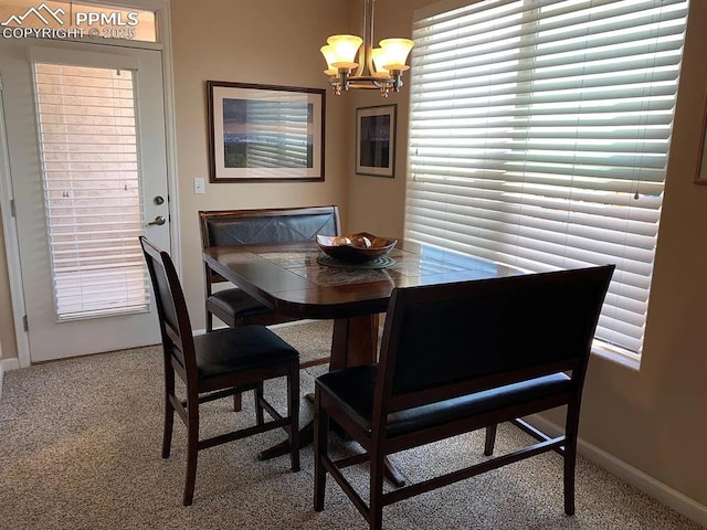 dining space with carpet floors and a notable chandelier