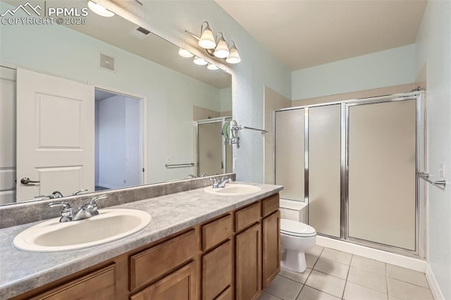 bathroom with vanity, tile patterned floors, a shower with shower door, and toilet