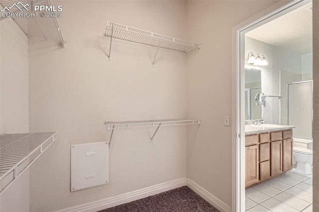 walk in closet with sink and light tile patterned flooring