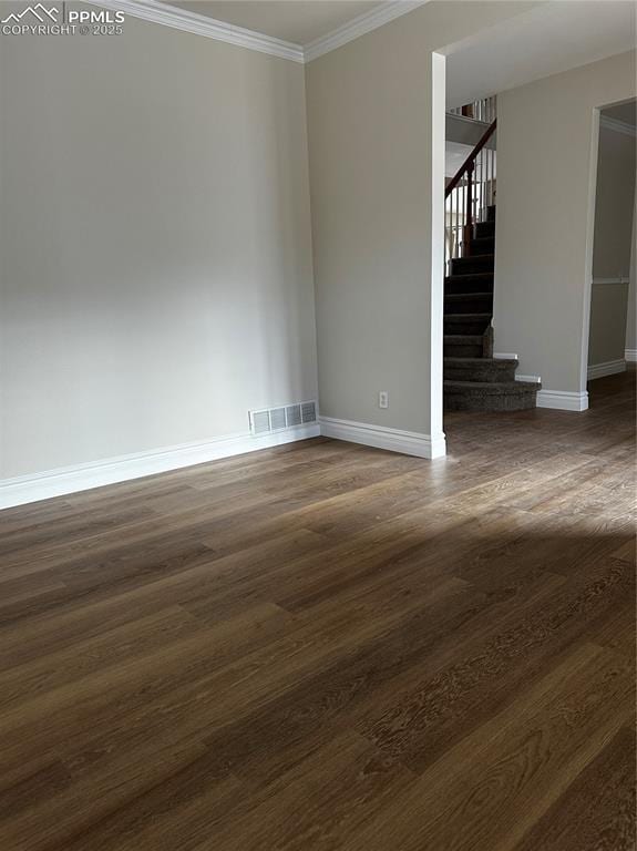 spare room with ornamental molding and dark wood-type flooring