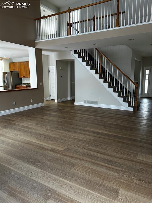 unfurnished living room featuring hardwood / wood-style floors and a high ceiling