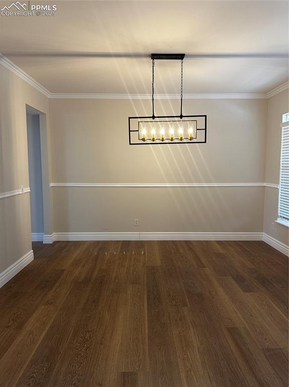 unfurnished dining area featuring dark hardwood / wood-style flooring and crown molding