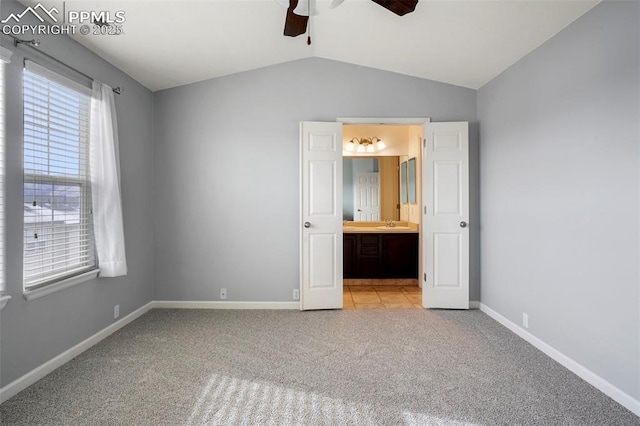 unfurnished bedroom with vaulted ceiling, light colored carpet, and ensuite bathroom