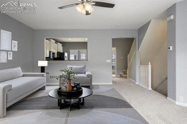 living room featuring light carpet and ceiling fan