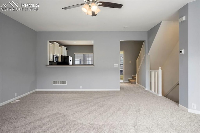 unfurnished living room featuring light colored carpet and ceiling fan