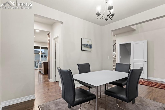 dining area with dark hardwood / wood-style floors and a chandelier